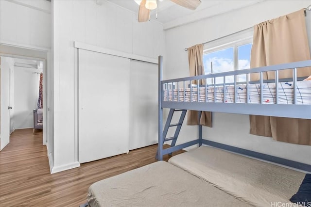 bedroom with ceiling fan, a closet, and wood finished floors