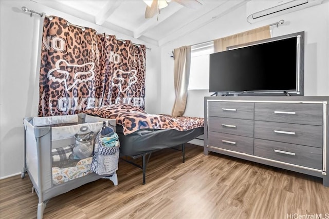 bedroom featuring a ceiling fan, a wall unit AC, vaulted ceiling with beams, and wood finished floors