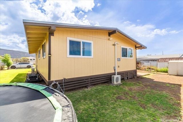 view of home's exterior with ac unit, fence, and a yard