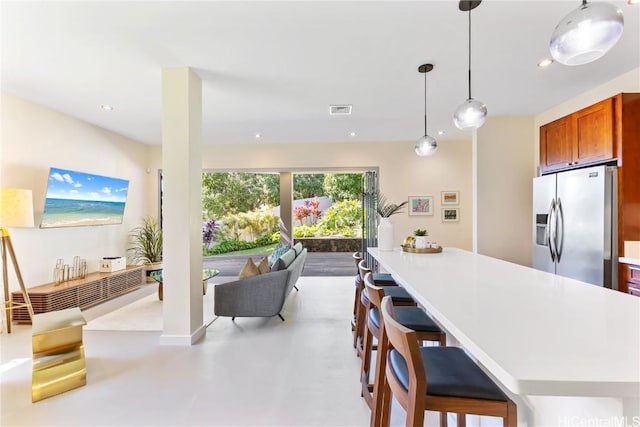 kitchen featuring hanging light fixtures, stainless steel fridge, and a breakfast bar