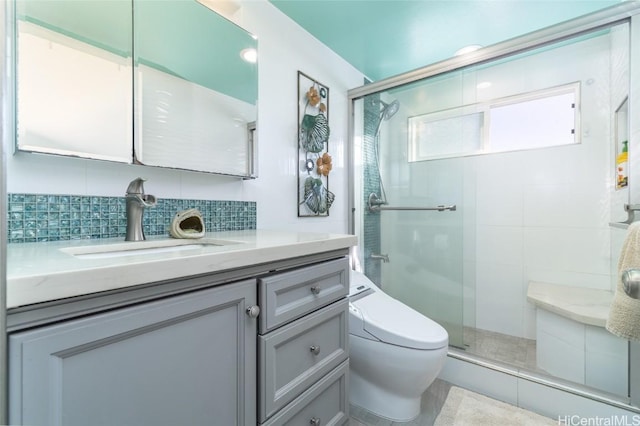 bathroom featuring vanity, backsplash, toilet, and an enclosed shower