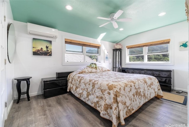 bedroom featuring multiple windows, vaulted ceiling, wood-type flooring, and a wall unit AC