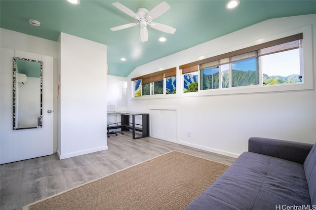 living room with ceiling fan, lofted ceiling, and wood-type flooring