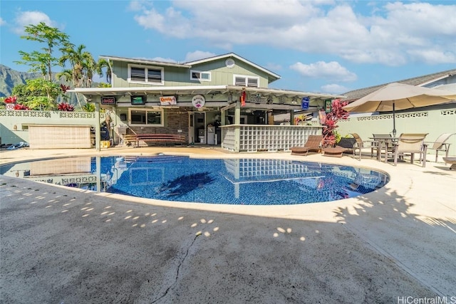 view of swimming pool featuring exterior bar and a patio