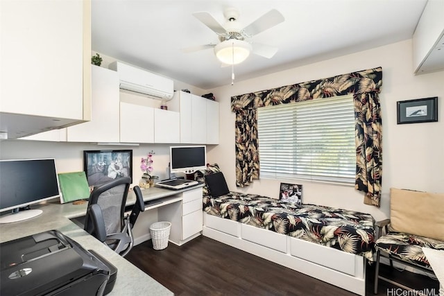 office area with dark hardwood / wood-style flooring, an AC wall unit, built in desk, and ceiling fan