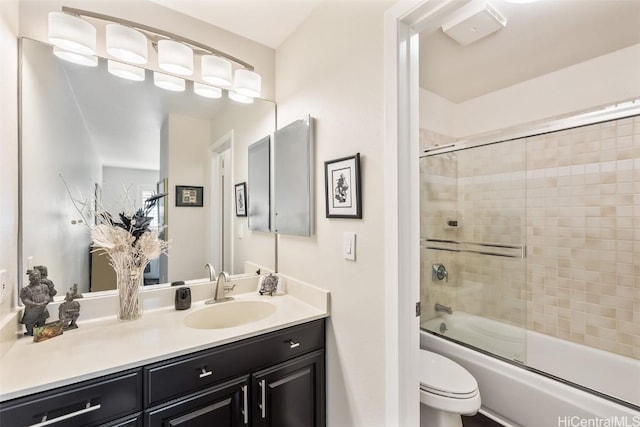 full bathroom featuring vanity, shower / bath combination with glass door, and toilet