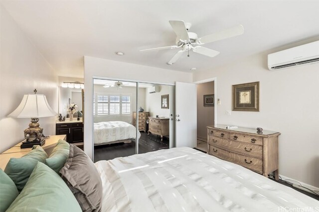 bedroom featuring a wall unit AC, a closet, ceiling fan, and ensuite bathroom