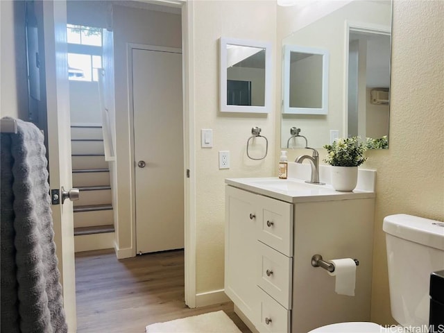 bathroom featuring vanity, hardwood / wood-style flooring, and toilet