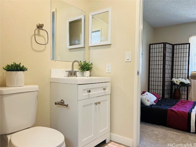 bathroom with vanity, a textured ceiling, and toilet