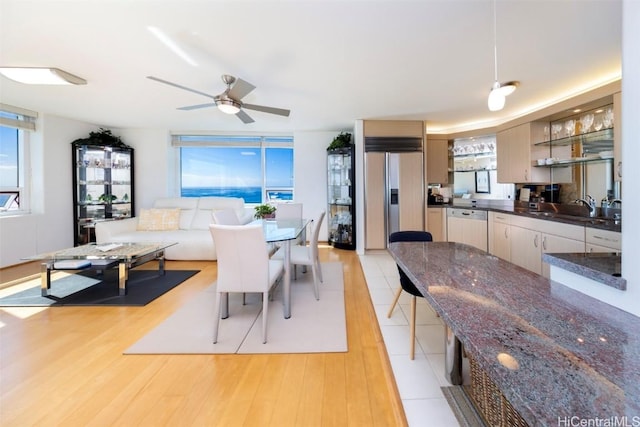 dining area featuring ceiling fan, sink, and light hardwood / wood-style flooring