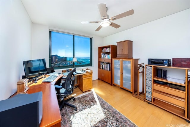 home office featuring light hardwood / wood-style flooring and ceiling fan