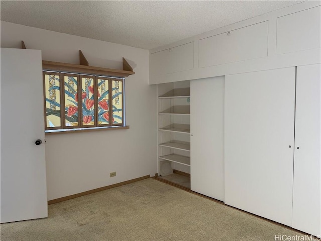 unfurnished bedroom with light colored carpet, a textured ceiling, and a closet