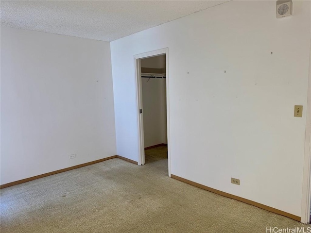 unfurnished room featuring light colored carpet and a textured ceiling