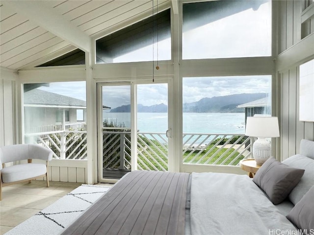 bedroom featuring lofted ceiling with beams, light tile patterned floors, a water and mountain view, and access to outside