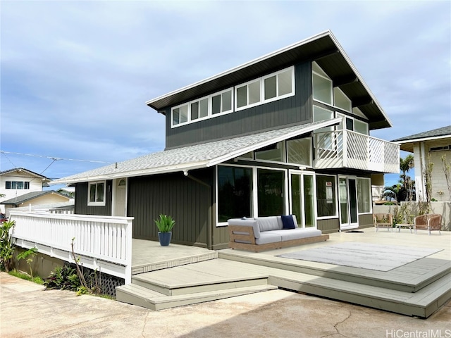 back of property with an outdoor hangout area and a deck