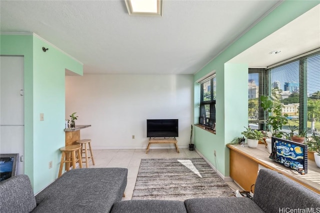 living room with light tile patterned floors and ornamental molding