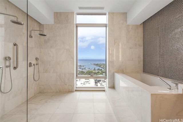 bathroom with independent shower and bath, a water view, and tile walls