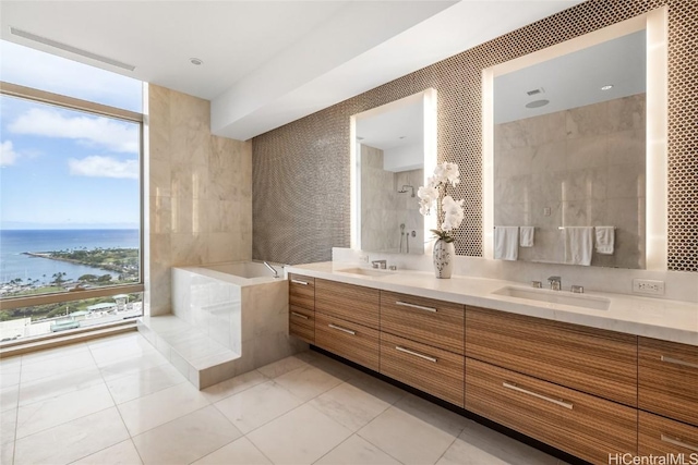 bathroom with vanity, a wealth of natural light, a bathing tub, and a water view