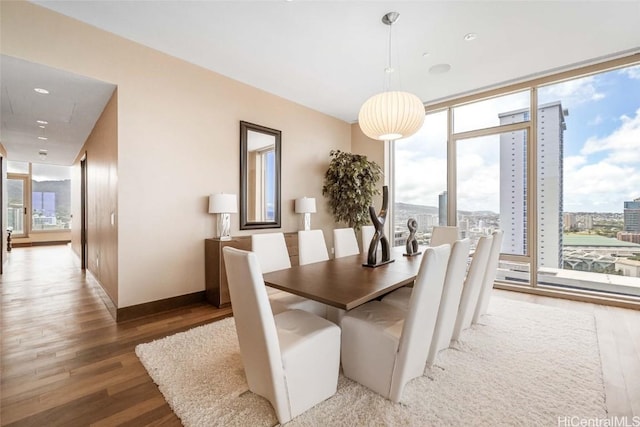 dining area featuring hardwood / wood-style floors and a wall of windows