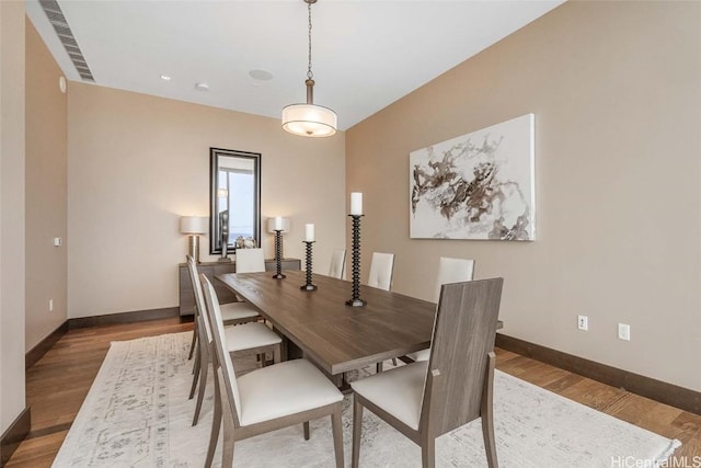 dining space with wood-type flooring