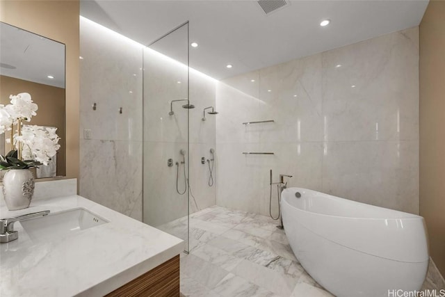 bathroom with independent shower and bath, vanity, and tile walls