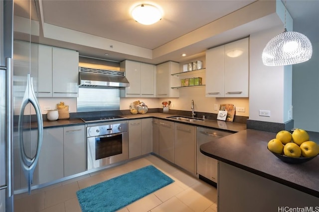 kitchen with sink, extractor fan, white cabinetry, decorative light fixtures, and appliances with stainless steel finishes