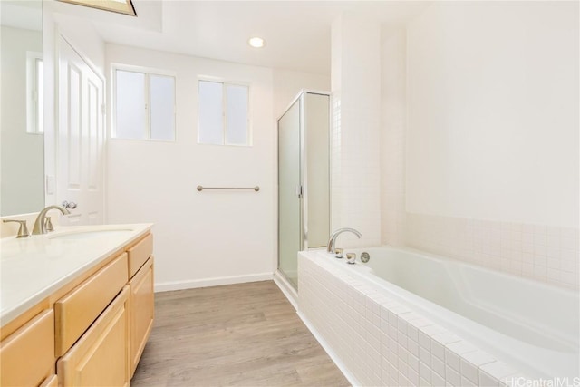 bathroom featuring vanity, separate shower and tub, and hardwood / wood-style floors