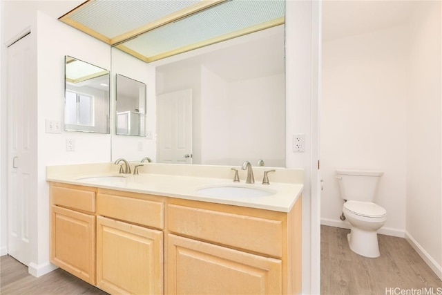 bathroom with vanity, hardwood / wood-style floors, and toilet