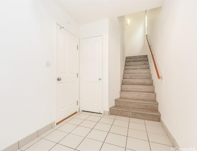 staircase featuring tile patterned flooring