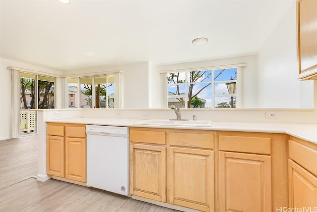 kitchen with white dishwasher, light hardwood / wood-style floors, sink, and light brown cabinets