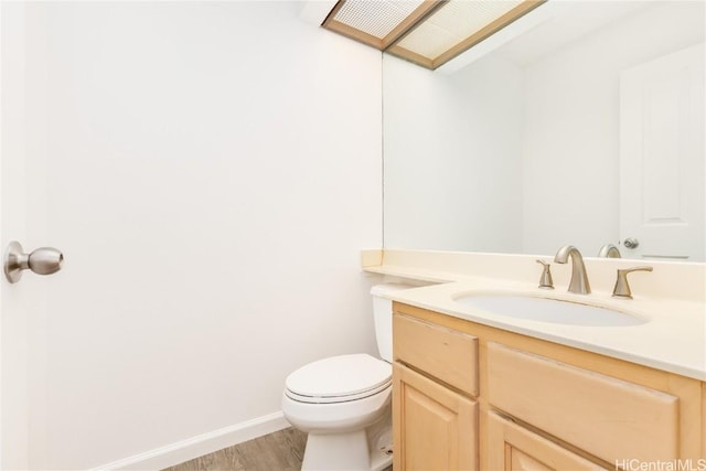 bathroom with vanity, hardwood / wood-style floors, and toilet