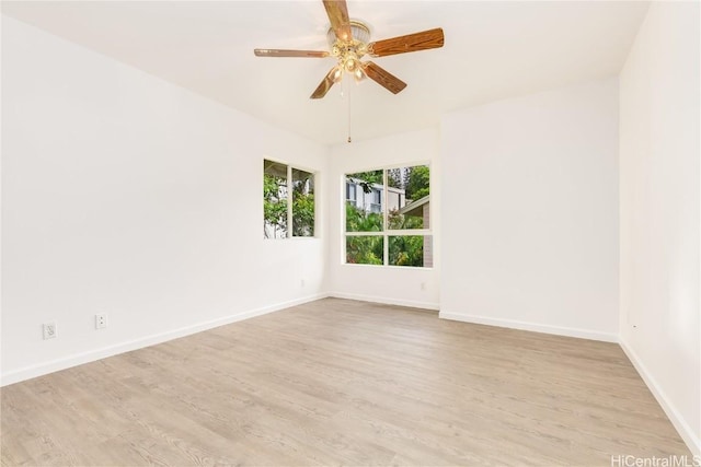 empty room with ceiling fan and light hardwood / wood-style flooring