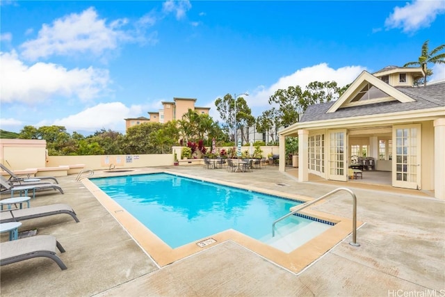 view of swimming pool featuring a patio area and french doors