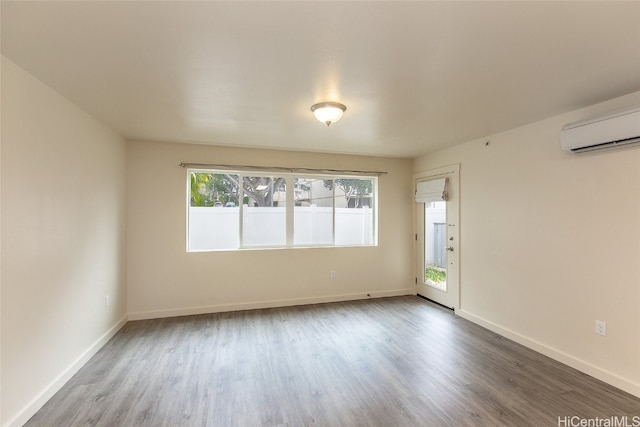 empty room featuring hardwood / wood-style floors and an AC wall unit