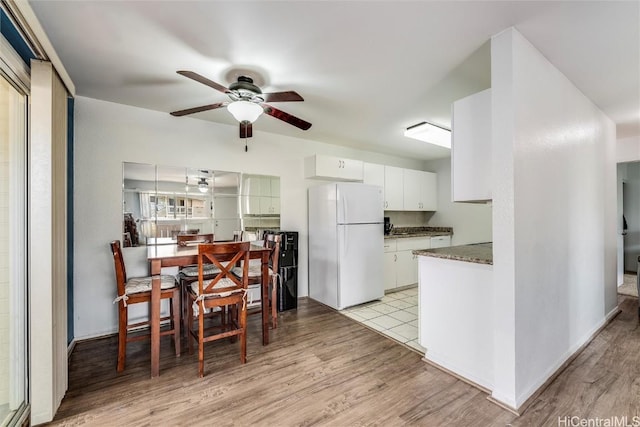 dining space featuring ceiling fan and light wood-type flooring