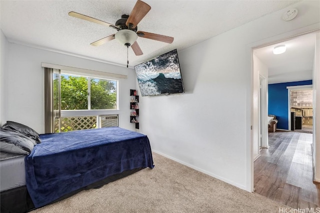 bedroom featuring ceiling fan, a wall unit AC, carpet floors, and a textured ceiling