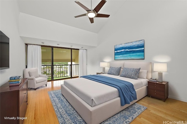 bedroom featuring light wood-type flooring, access to outside, high vaulted ceiling, and baseboards