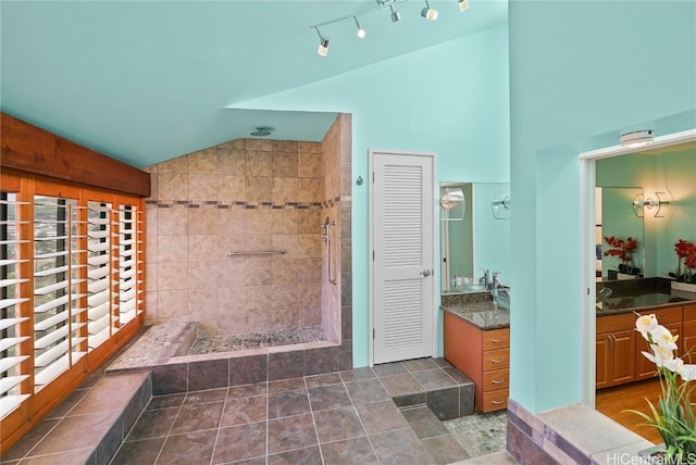 full bathroom with lofted ceiling, tile patterned flooring, vanity, and walk in shower