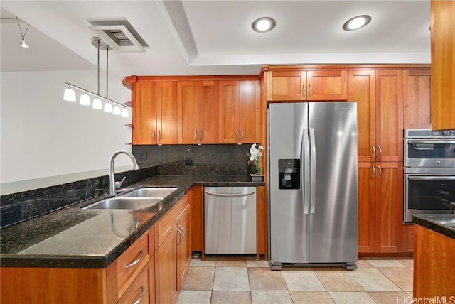 kitchen with stainless steel appliances, a sink, and brown cabinets