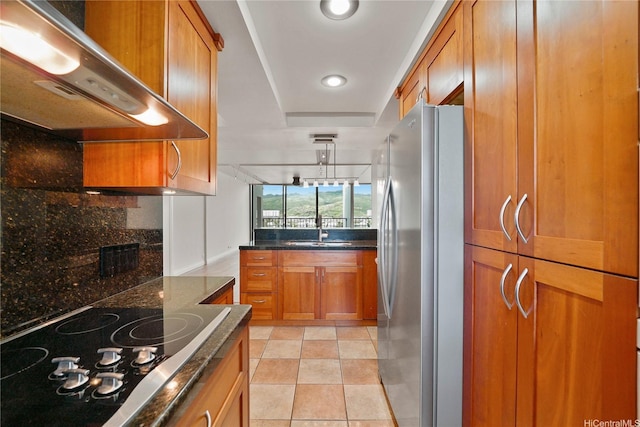 500 Lunalilo Home Rd Unit 28G, Honolulu, HI 96825 - kitchen with brown cabinetry, black electric cooktop, a sink, freestanding refrigerator, and under cabinet range hood