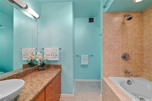 full bath featuring tile patterned flooring, vanity, visible vents, tiled shower / bath, and baseboards