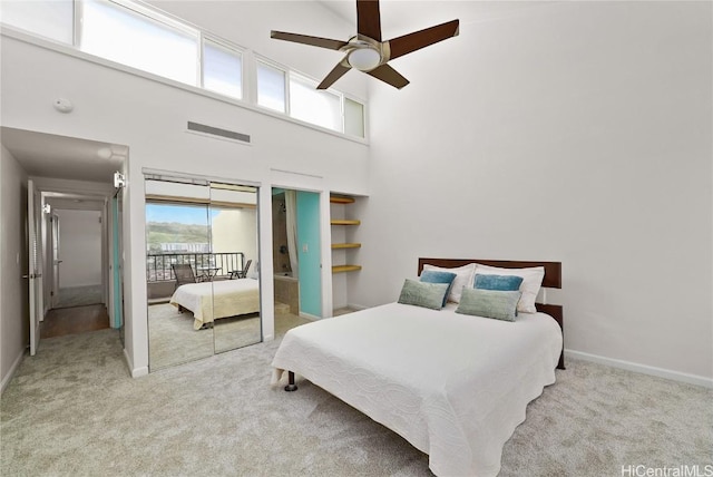 carpeted bedroom featuring ceiling fan, a high ceiling, visible vents, and baseboards