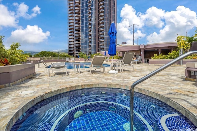 view of pool featuring a community hot tub and a patio area