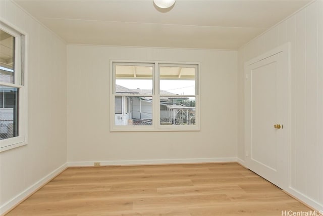 empty room featuring crown molding and light wood-type flooring