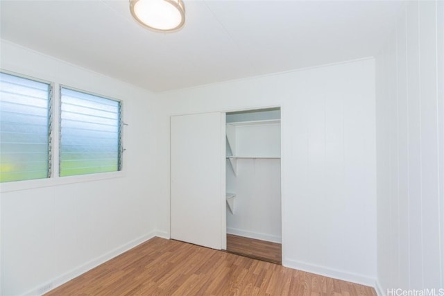 unfurnished bedroom with hardwood / wood-style flooring and a closet