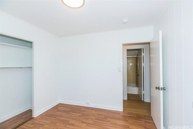 unfurnished bedroom featuring wood-type flooring and a closet