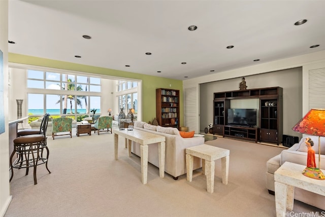 carpeted living room featuring a water view