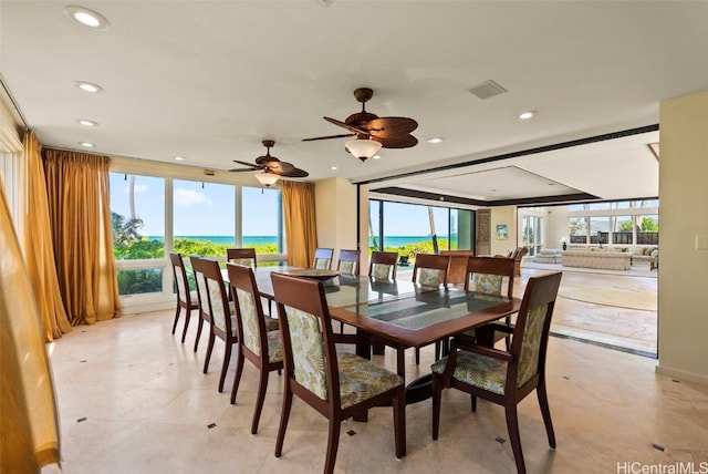 dining space featuring a water view and a healthy amount of sunlight