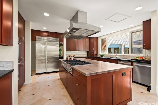 kitchen featuring stainless steel appliances, island exhaust hood, a kitchen island, and sink