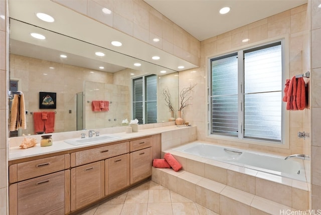 bathroom featuring tile patterned floors, vanity, plus walk in shower, and tile walls